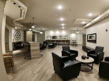 Creekside Common room lounge area with chairs tables and a fireplace